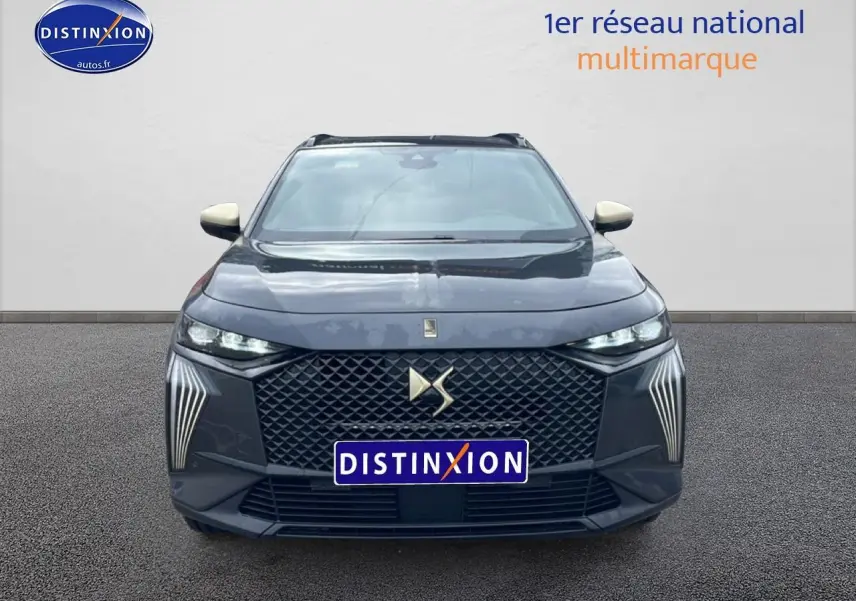 Vue avant d'un DS7 gris titane avec calandre hexagonale et feux LED verticaux distinctifs allumés.