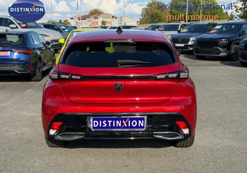 Vue arrière d'une Peugeot 308 rouge Elixir 2025, avec feux arrière LED et logo lion central bien visible.