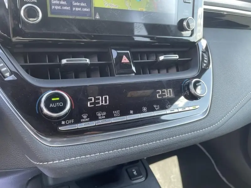 Gros plan sur la console centrale de la Toyota Corolla 184 H Collection 2019, affichant la climatisation à 23°C.