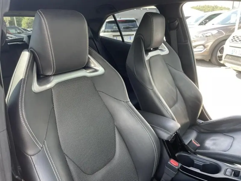 Gros plan sur les sièges avant en cuir noir avec surpiqûres blanches de la Toyota Corolla 184 H Collection 2019.