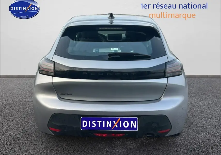 Vue arrière d'une Peugeot 208 gris artense 2025 avec feux arrière noirs et lunette arrière teintée.