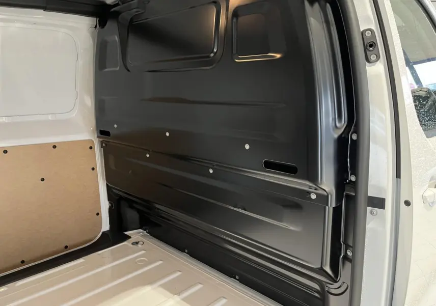 Vue intérieure côté droit de l'espace de chargement blanc du Peugeot Expert Fourgon 2024 avec cloison noire tôlée.