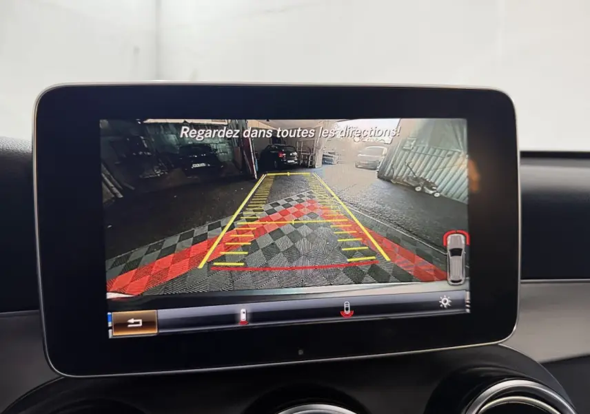 Écran central montrant la caméra de recul avec guidage de trajectoire dans un Mercedes GLC 250 gris foncé.