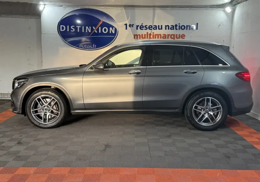 Mercedes GLC 250 Fascination 4Matic gris foncé, vue de profil côté gauche en intérieur avec jantes alliage visibles.