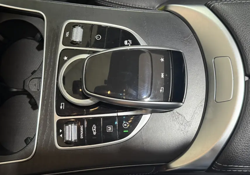 Gros plan sur la console centrale noire et argentée du Mercedes GLC 250 Fascination 2019 avec commandes tactiles et molette.