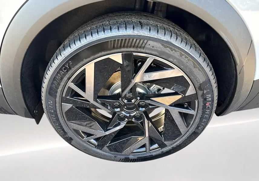 Gros plan sur la roue avant droite du Renault Symbioz gris rafale, jante alu noire au design géométrique.