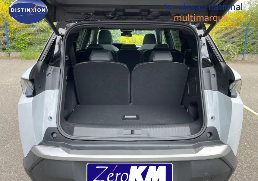 Vue arrière du Peugeot 5008 Hybrid blanc Okenite avec toit noir, coffre ouvert montrant les sièges arrière.