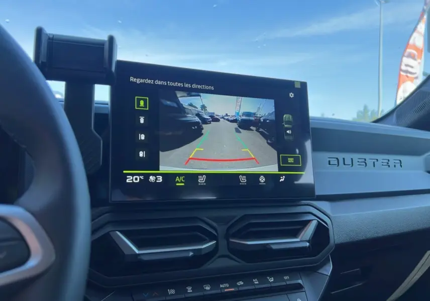 Vue intérieure du tableau de bord du Dacia Duster 2025 avec écran multimédia affichant la caméra de recul.