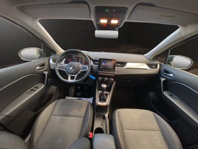 Vue intérieure avant du Renault Captur TCE 90 Équilibre 2023 avec tableau de bord gris noir et boîte manuelle.