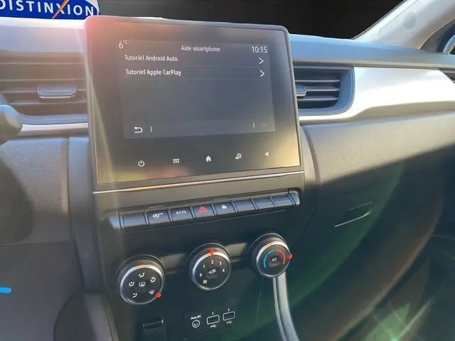 Vue rapprochée du tableau de bord gris noir du Renault Captur 2023 avec écran tactile et commandes de climatisation.