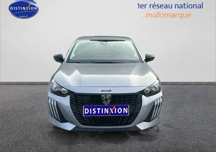 Vue frontale d'une Peugeot 208 gris artense avec calandre noire et phares LED distinctifs.