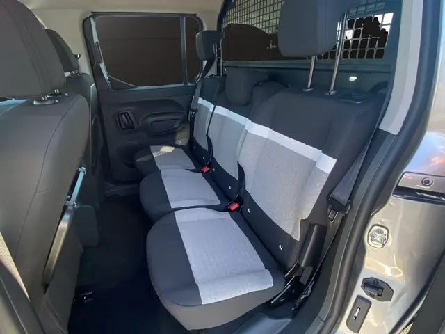Vue intérieure côté droit des sièges arrière gris clair et noir du Citroën Berlingo N1 BlueHDi 130 2025 avec cloison de séparation.