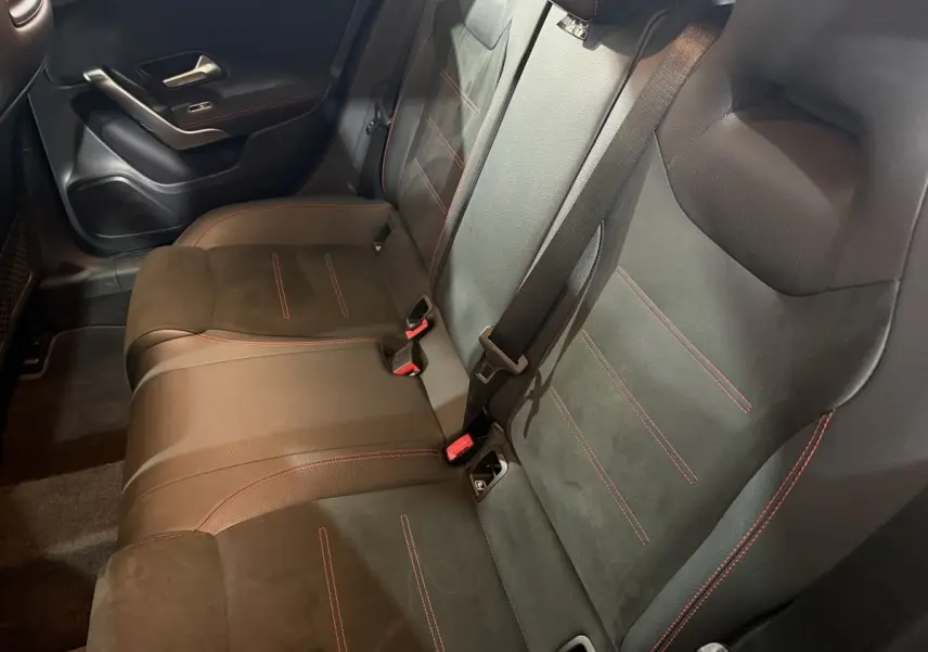 Vue intérieure côté droit montrant la banquette arrière en cuir noir avec surpiqûres rouges de la Mercedes Classe A A 200 AMG Line.