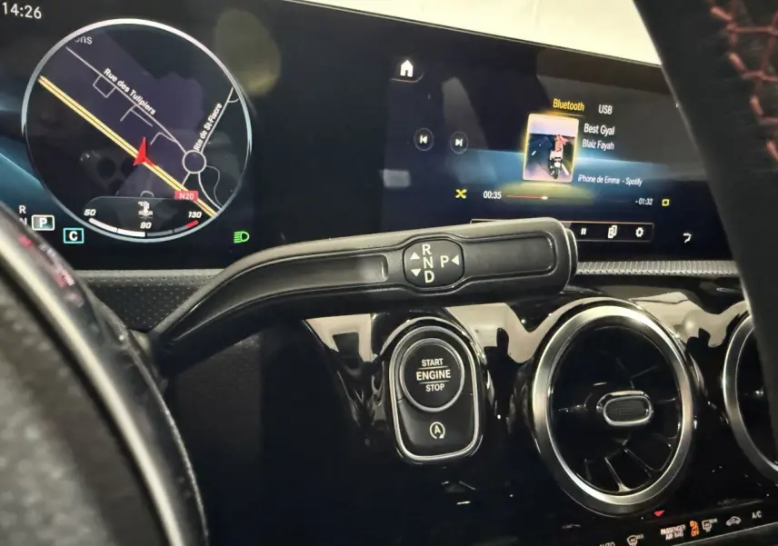 Vue rapprochée de l'intérieur de la Mercedes Classe A 200 AMG Line 2021, tableau de bord noir avec écran tactile et bouton start/stop.