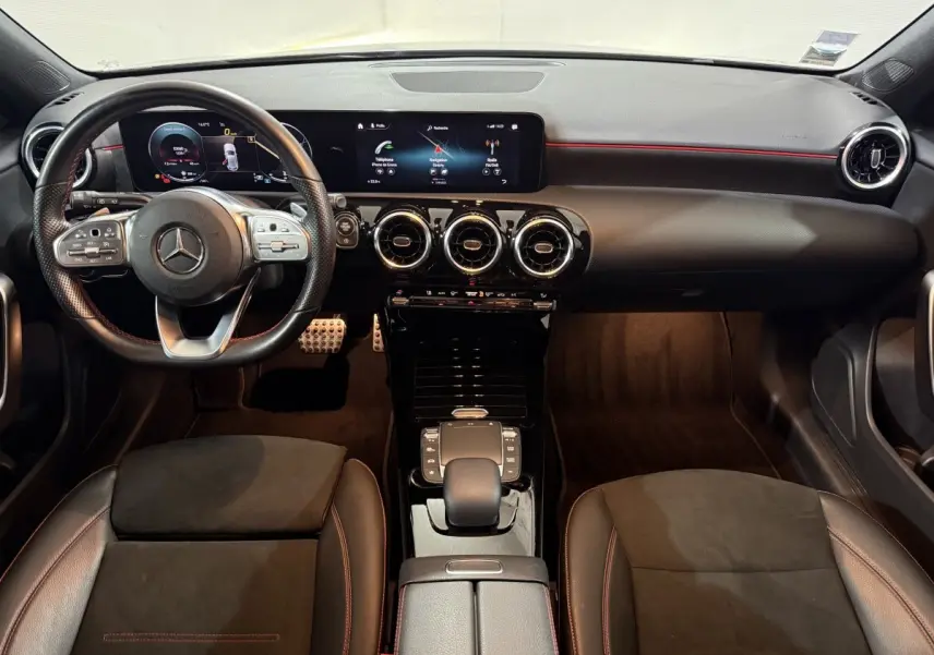 Vue intérieure frontale du tableau de bord et volant cuir noir avec surpiqûres rouges de la Mercedes Classe A A 200 AMG Line.