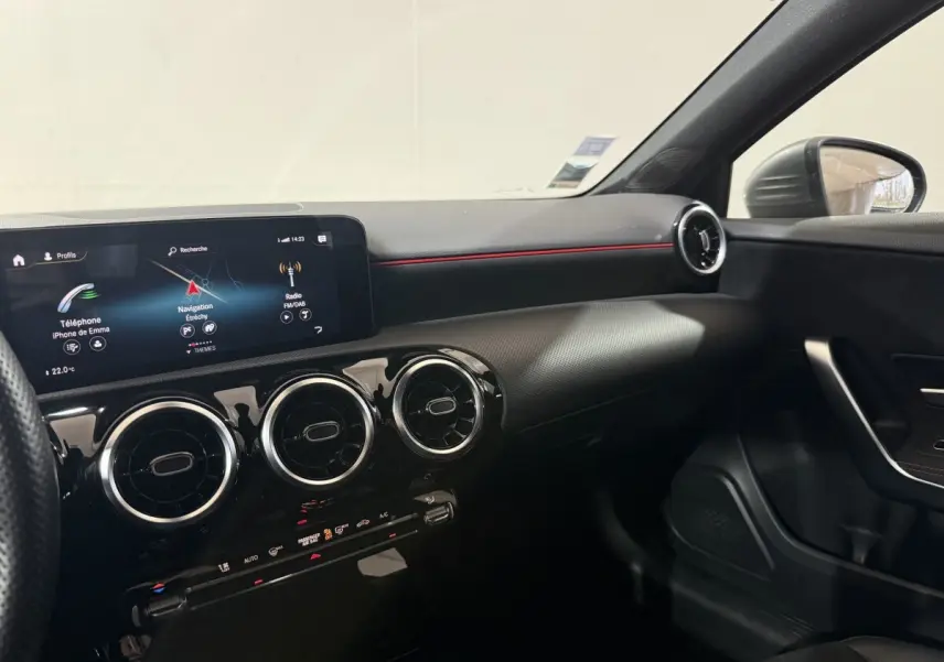 Vue intérieure côté passager de la Mercedes Classe A 200 AMG Line 2021, tableau de bord noir avec écran tactile et aérateurs ronds.