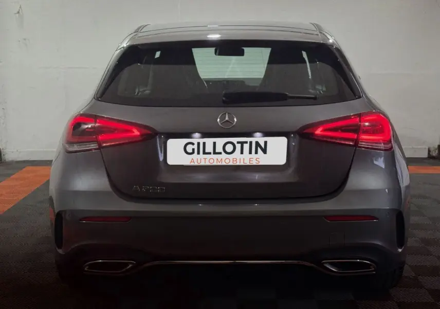 Vue arrière d'une Mercedes Classe A 200 AMG Line gris foncé avec feux LED allumés dans un garage.