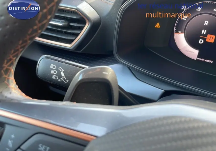 Gros plan sur le volant et le combiné d'instruments du CUPRA Formentor blanc neige métal, affichant la boîte automatique en mode parking.