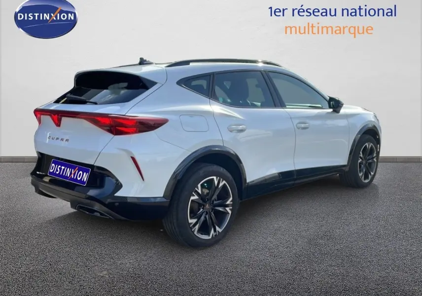 Vue 3/4 arrière droite d'un CUPRA Formentor blanc neige métal avec jantes noires bicolores et feux arrière LED distinctifs.