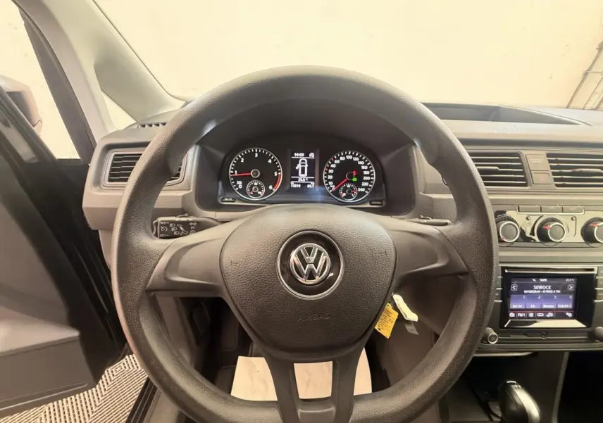 Vue intérieure centrée sur le volant noir Volkswagen Caddy 2019 avec tableau de bord et écran tactile visibles.