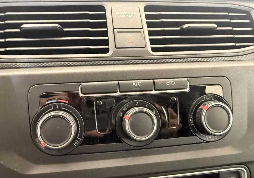 Gros plan sur les commandes de climatisation du tableau de bord du Volkswagen Caddy noir 2019.