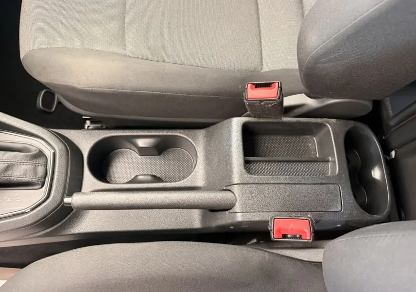Vue plongeante sur la console centrale noire du Volkswagen Caddy 2019 avec levier de vitesse et porte-gobelets.