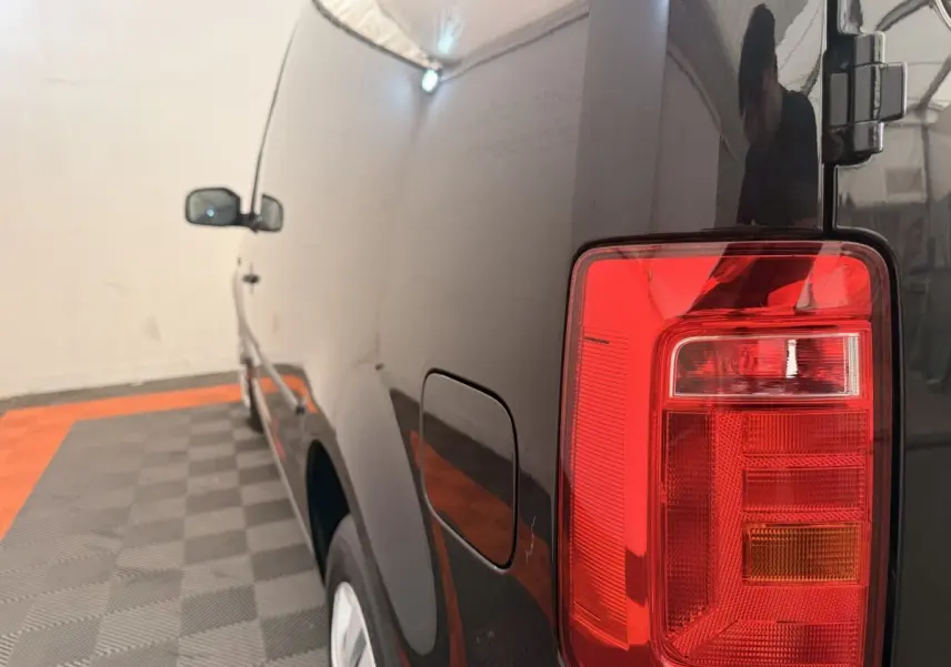Vue arrière côté droit du Volkswagen Caddy noir 2019 avec feu arrière rouge et porte de réservoir visible.