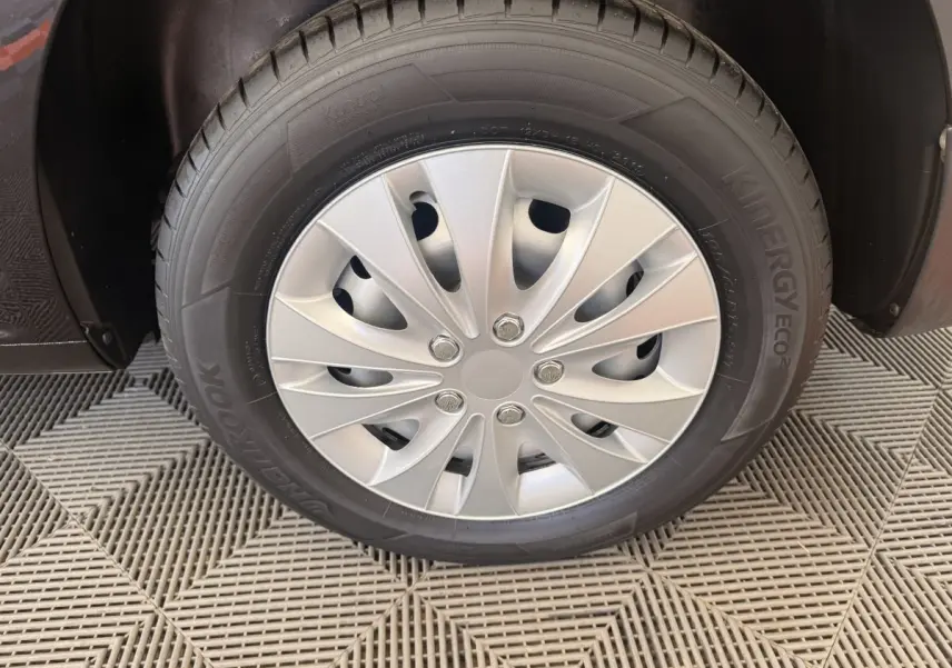 Gros plan sur la roue avant droite du Volkswagen Caddy noir avec enjoliveur argenté et pneu Hankook.