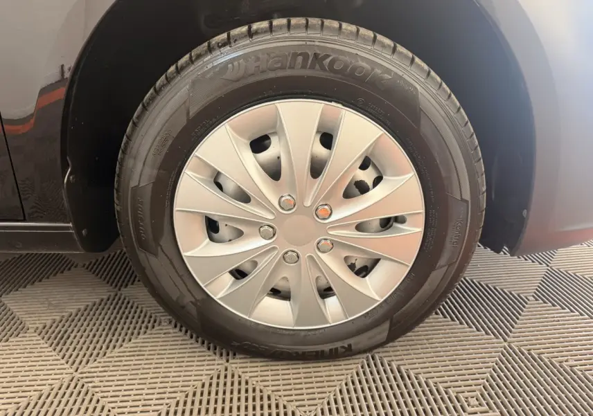 Gros plan sur la roue avant droite du Volkswagen Caddy noir 2019 avec jante acier et pneu Hankook.