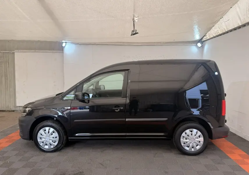Vue latérale gauche d'un Volkswagen Caddy noir 2019, fourgon compact avec jantes acier et portes latérales lisses.