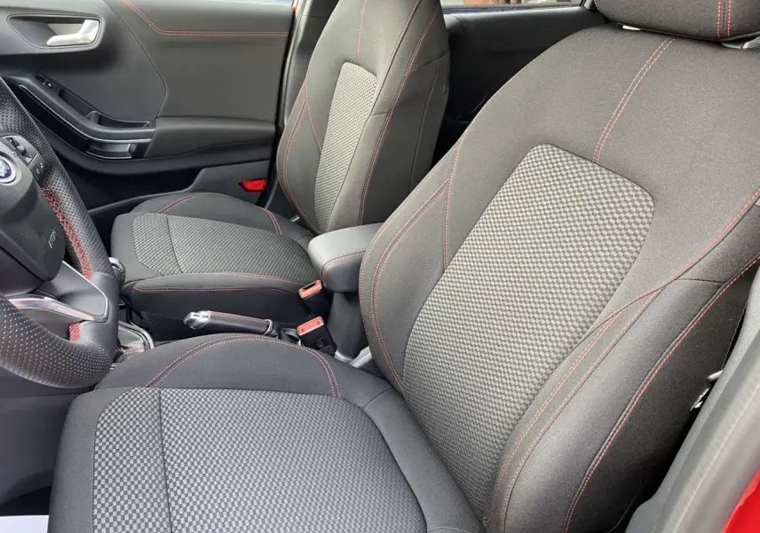 Vue intérieure côté conducteur du Ford Puma ST-Line 2022 avec sièges tissu gris à surpiqûres rouges et porte rouge Fantastic.