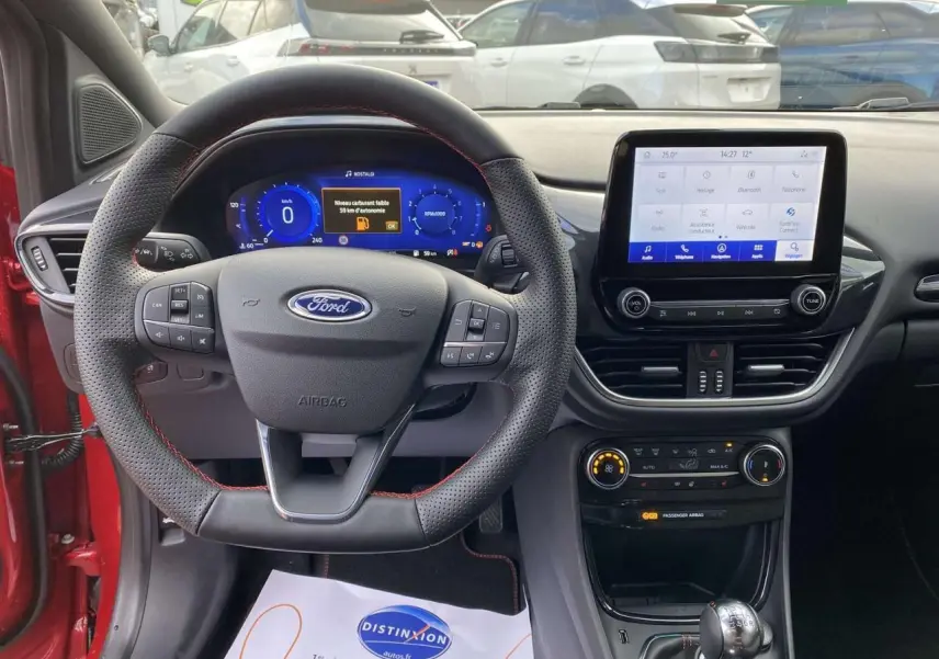Vue intérieure frontale du tableau de bord et volant perforé avec coutures rouges du Ford Puma rouge 2022 ST-Line.