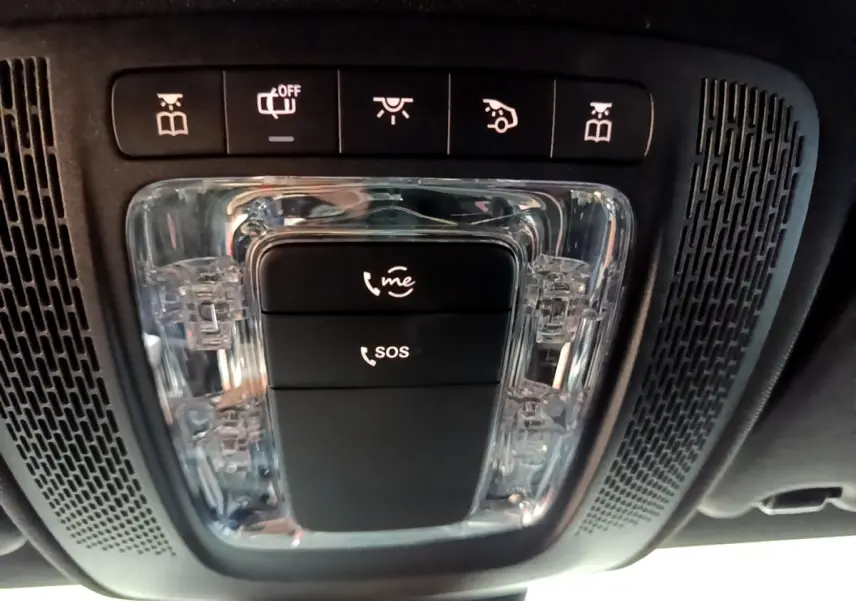 Gros plan sur la console de toit noire de la Mercedes Classe A 200 AMG Line avec boutons d’appel SOS et assistance.
