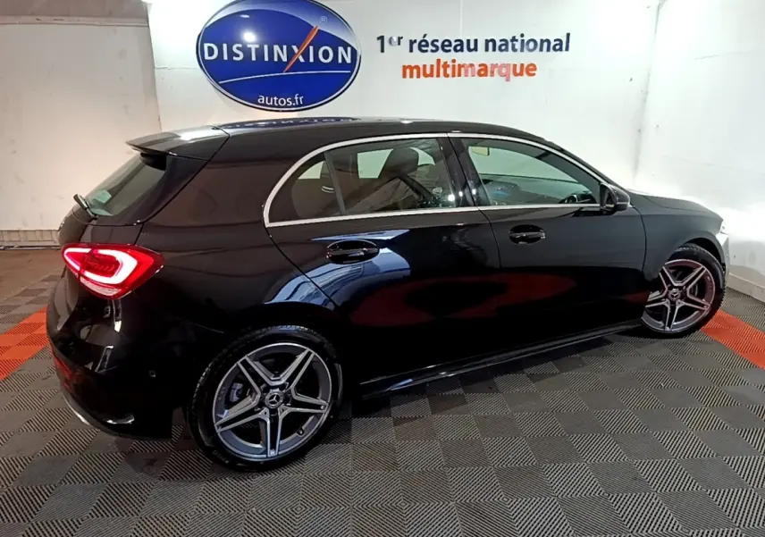 Vue 3/4 arrière droite d'une Mercedes Classe A 200 AMG Line noire, avec jantes alliage et feux LED allumés.