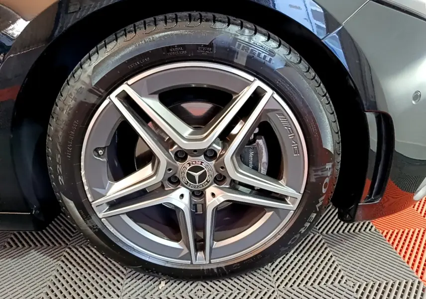 Gros plan sur la jante AMG argentée et le pneu Pirelli d’une Mercedes Classe A noire, côté arrière droit.