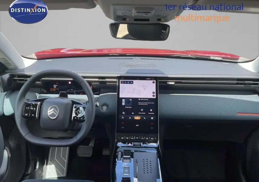 Vue intérieure frontale du tableau de bord du Citroën C5 Aircross Hybrid rouge rubis, avec écran tactile vertical et volant multifonction.