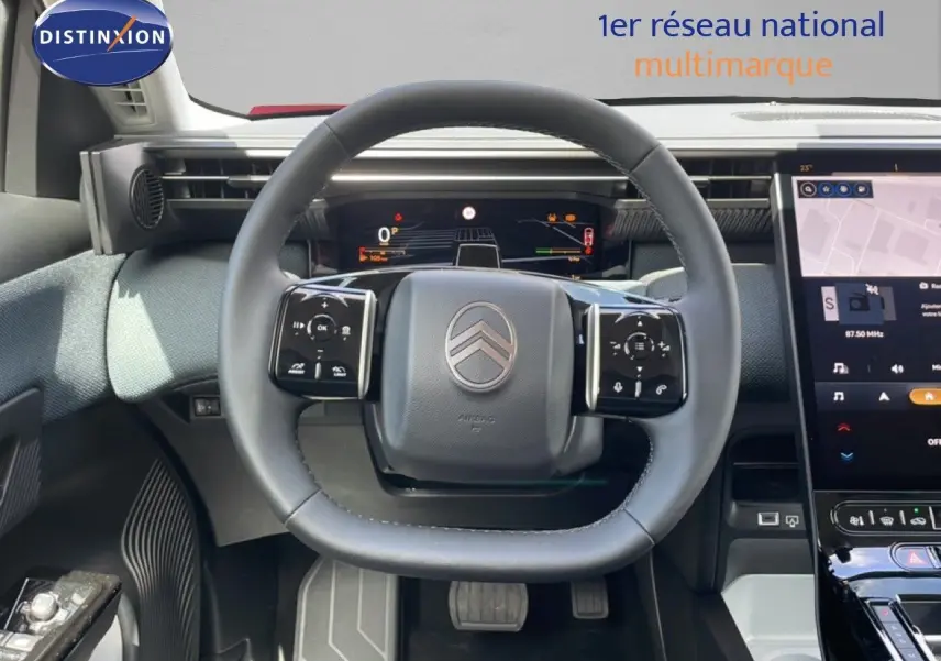 Vue intérieure centrée sur le volant cuir du Citroën C5 Aircross Hybrid, avec tableau de bord numérique et écran tactile.