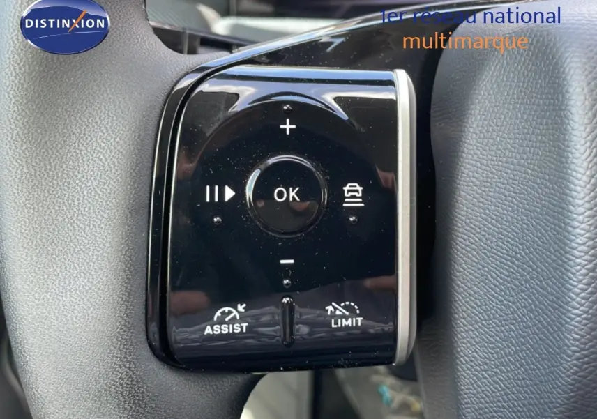 Gros plan sur les commandes du volant du Citroën C5 Aircross Hybrid rouge rubis, avec boutons de régulateur et limiteur de vitesse.