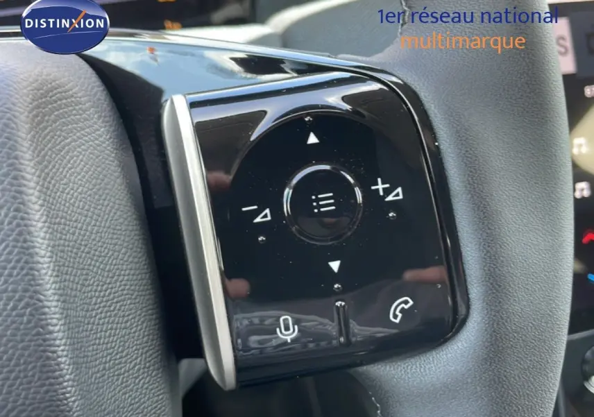Gros plan sur les commandes multifonctions noires du volant d’un Citroën C5 Aircross hybride rouge rubis.