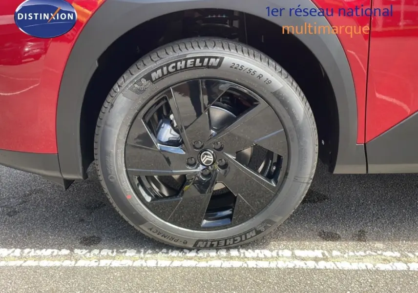 Gros plan sur la roue avant droite noire brillante du Citroën C5 Aircross Hybrid rouge rubis métallisé.