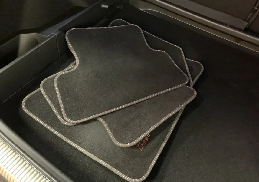 Gros plan sur les tapis de sol noirs avec surpiqûres claires dans le coffre du DS7 Crossback Gris Platinium 2022.