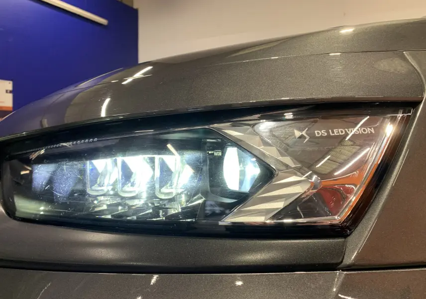 Gros plan sur le phare avant droit LED DS Vision du DS7 Crossback gris Platinium 2022, détails lumineux et design sculpté.