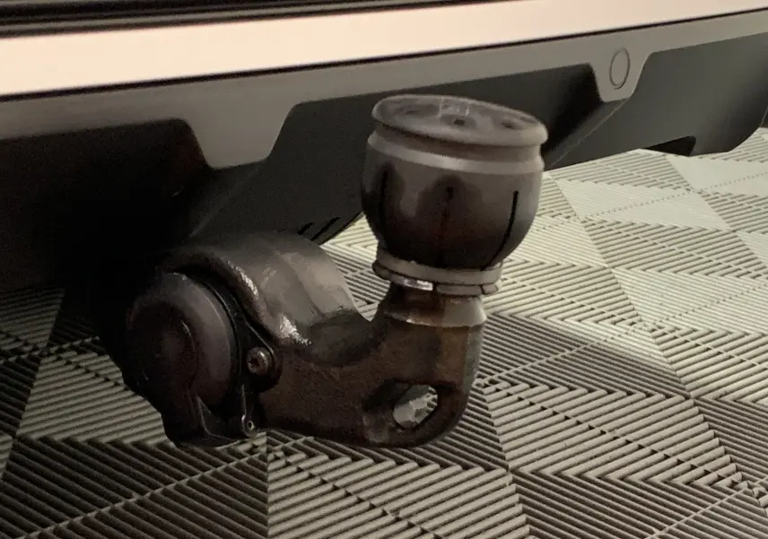 Gros plan sur l'attelage d'une DS7 Crossback gris Platinium, mettant en valeur la fixation robuste sous le pare-chocs arrière.