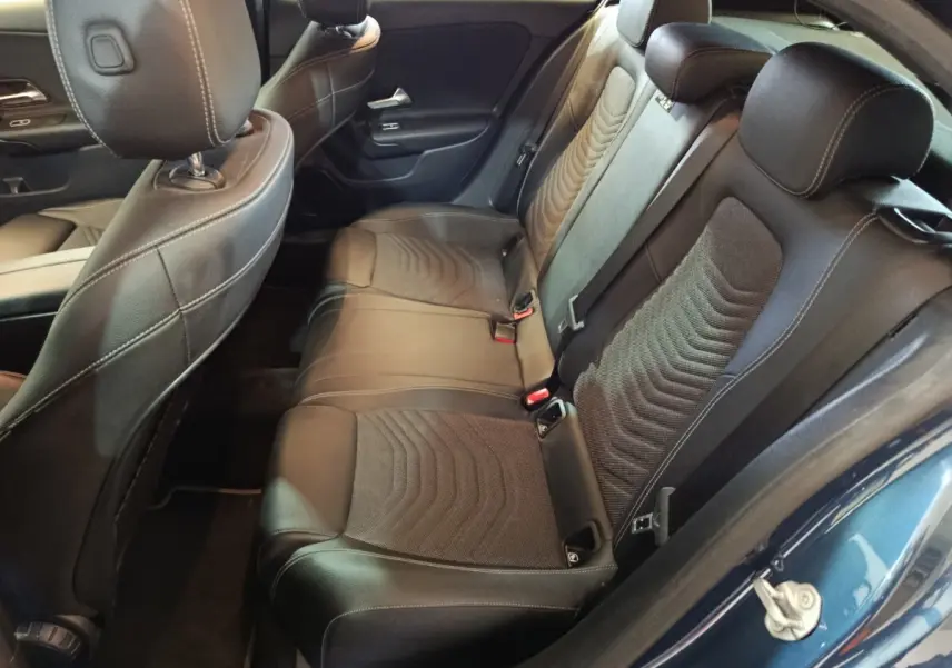 Vue intérieure côté arrière droit de la banquette en cuir noir de la Mercedes Classe A 250 e Business Line bleu.