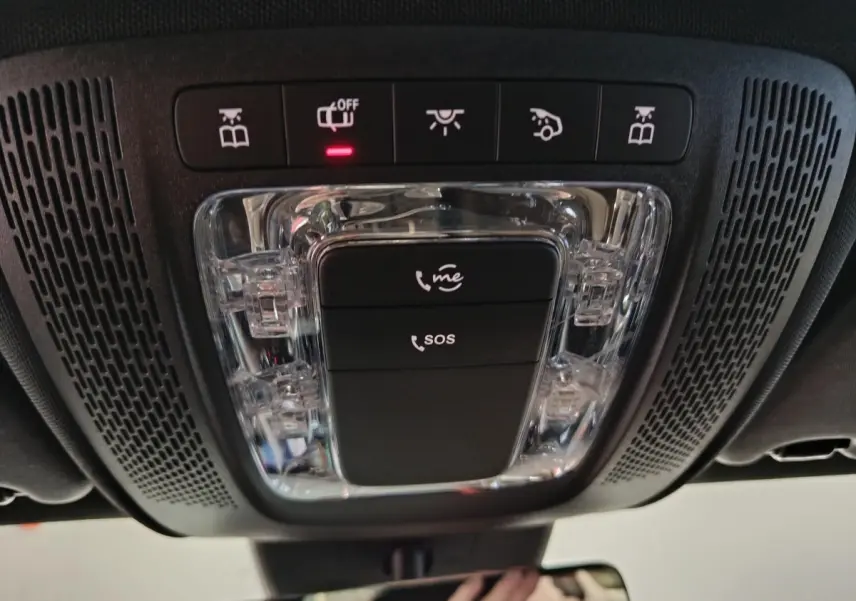 Vue intérieure en plongée sur la console de toit noire avec boutons SOS et éclairage de la Mercedes Classe A bleue.
