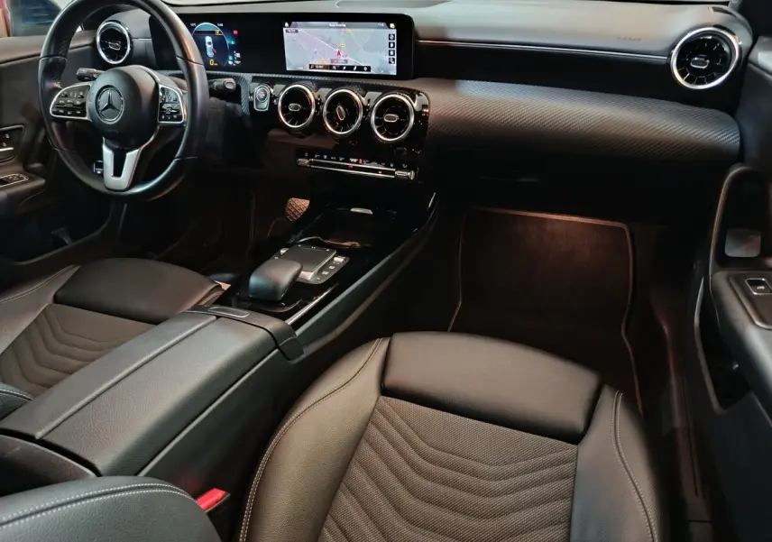 Vue intérieure avant droite de la Mercedes Classe A 250 e Business Line 2021, avec volant cuir et écran tactile large.