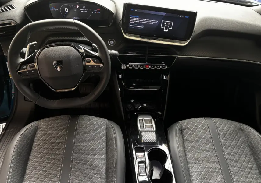 Vue intérieure avant du Peugeot 2008 Hybrid 145 Allure bleu, avec tableau de bord numérique et écran tactile central.