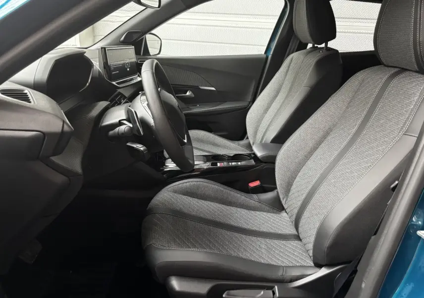 Vue intérieure côté conducteur du Peugeot 2008 Hybrid 145 e-DCS6 Allure bleu, mettant en valeur les sièges et le tableau de bord moderne.
