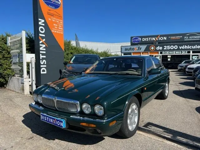 Jaguar Sovereign 3.2 V8 vert vue 3/4 avant droit sur parking devant concession Distinxion.