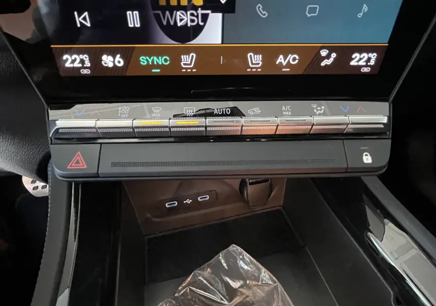 Vue rapprochée de la console centrale du Renault Rafale Esprit Alpine 2024, montrant les commandes climatisation et ports USB.